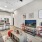 Spacious and well lit living room with wood flooring, large windows and open access to the kitchen