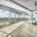 large room with wood floors and large windows 